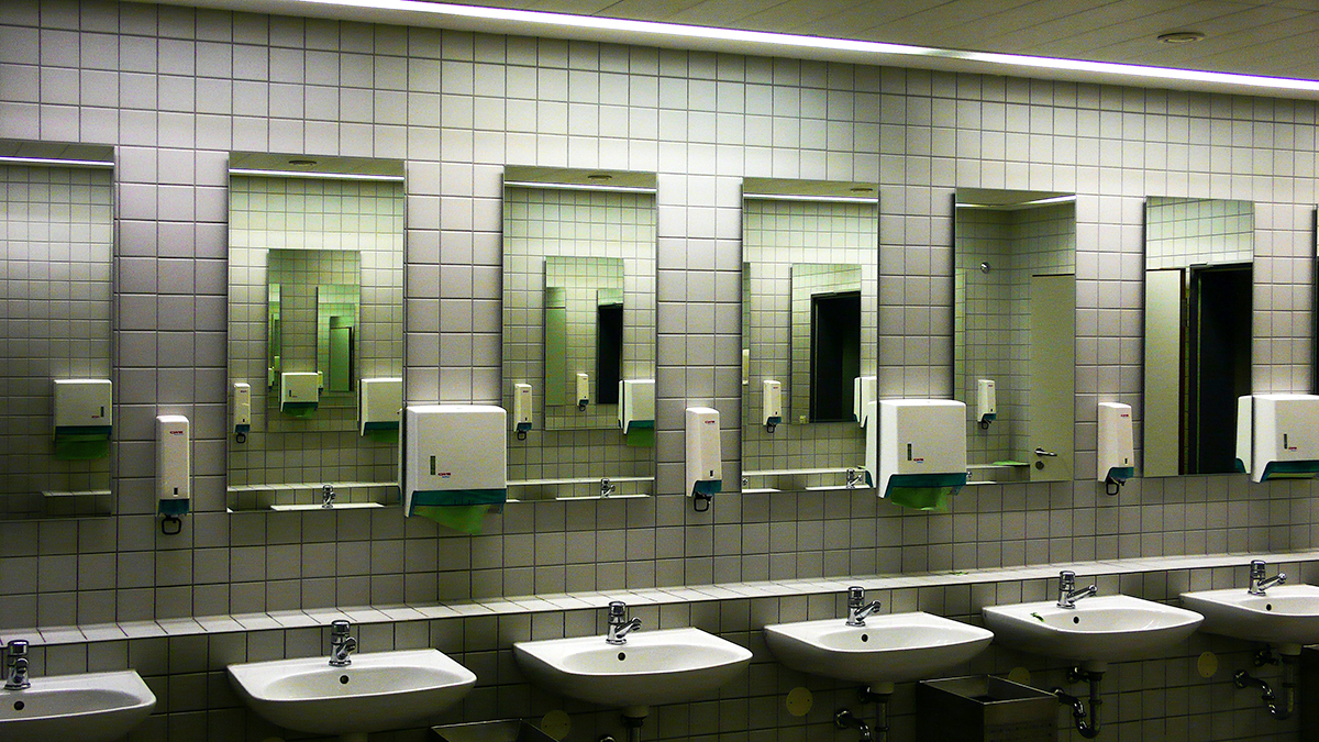 Rows of sinks in a public restroom at an office facility